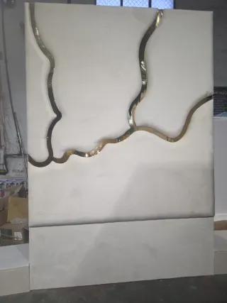 Cama tapizada con detalles dorados