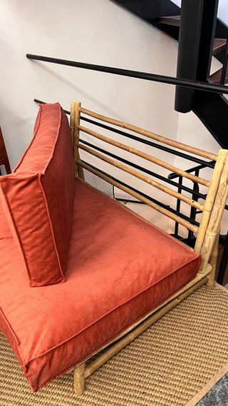 Sofá de bambú con cojines naranjas