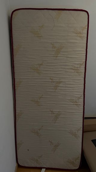 Base tapizada de colore beige con colchón