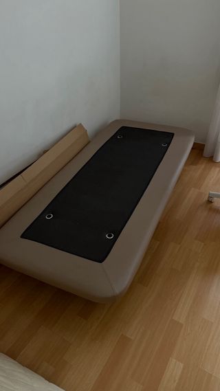Base tapizada de colore beige con colchón