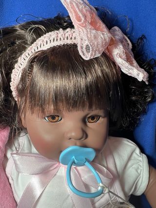 Bambola riccia con fiocco rosa piangente