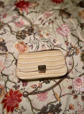 Bolso de mano beige con cadena dorada
