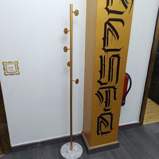 Perchero de pie dorado y mármol