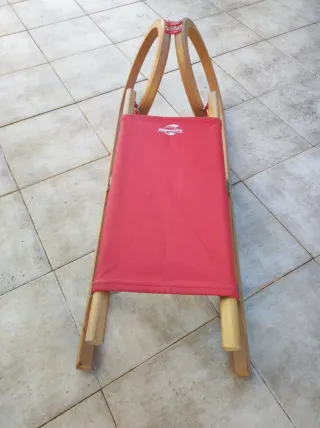 Trineo de madera y tela roja