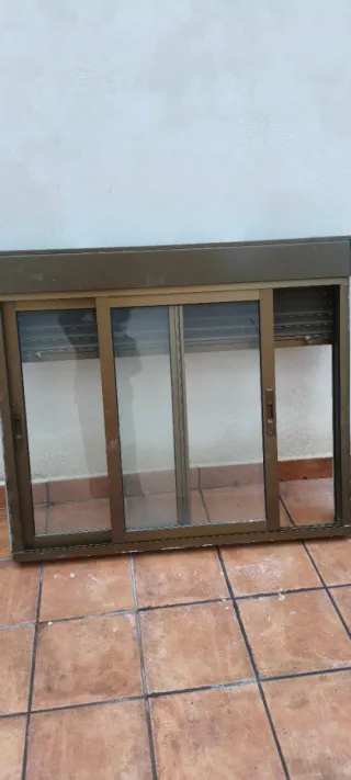 Ventana corredera de aluminio marrón, con persiana