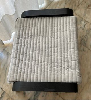 Sillón y reposapiés beige y negro. Poang