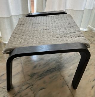 Sillón y reposapiés beige y negro. Poang