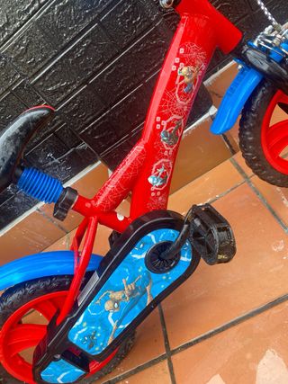 Bicicleta infantil roja con ruedas azules