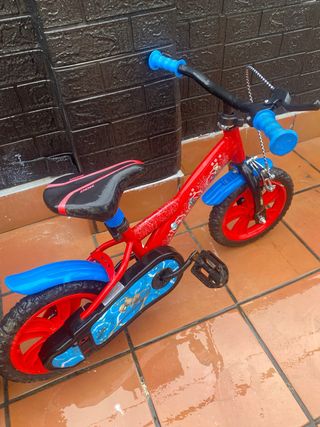 Bicicleta infantil roja con ruedas azules