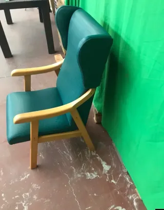 Sillón tapizado verde con patas de madera