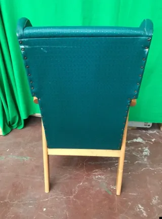 Sillón tapizado verde con patas de madera
