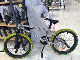 Bicicleta BMX plateada con ruedas verdes