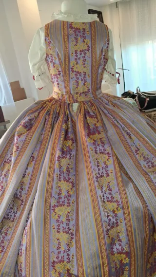 Traje dançaes dorado, morado y rojo.