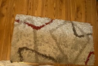 Alfombra beige y roja de poliéster