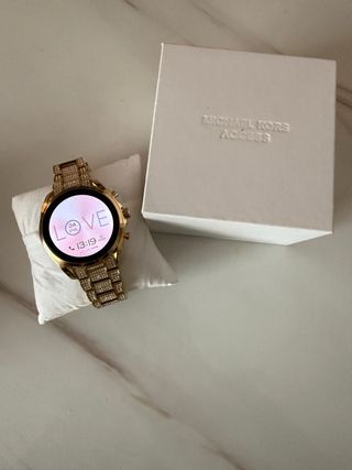 Reloj Michael Kors Dorado y plateado con celular.