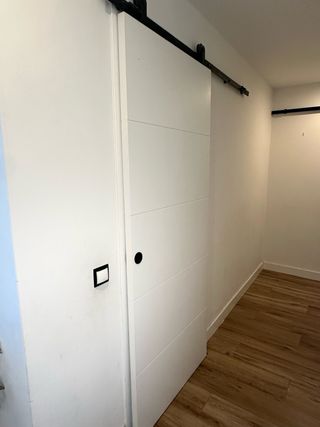 Puertas correderas blanca estilo granero con riel.