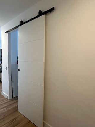 Puertas correderas blanca estilo granero con riel.