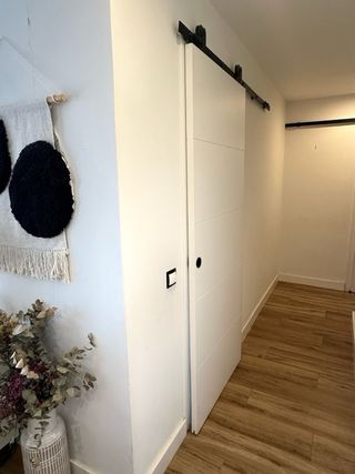 Puertas correderas blanca estilo granero con riel.