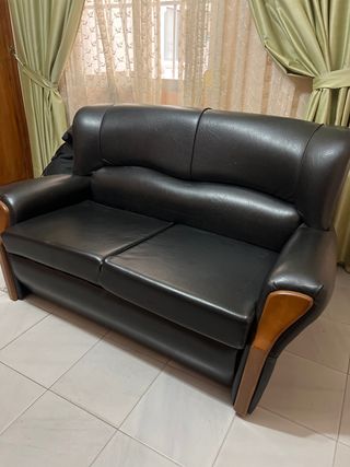 Sofá de piel negro con detalles de madera