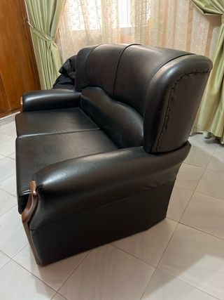 Sofá de piel negro con detalles de madera