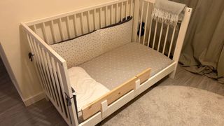 Cuna IKEA blanca con muchas cosas