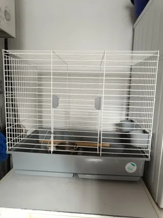 Jaula para pájaros blanca y gris.