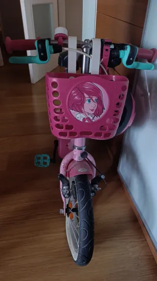 Bicicleta infantil rosa con casco