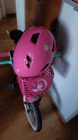 Bicicleta infantil rosa con casco