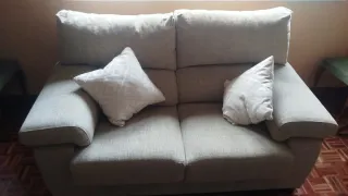 Sofá de tela beige con cojines blancos