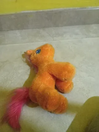 Unicornio de peluche naranja con cola rosa