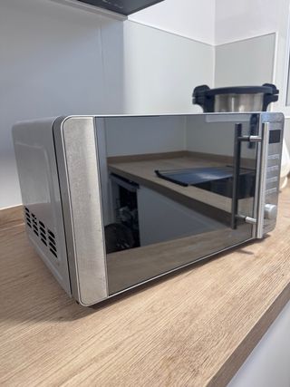 Microondas plateado con puerta de cristal