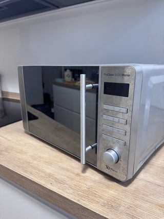 Microondas plateado con puerta de cristal