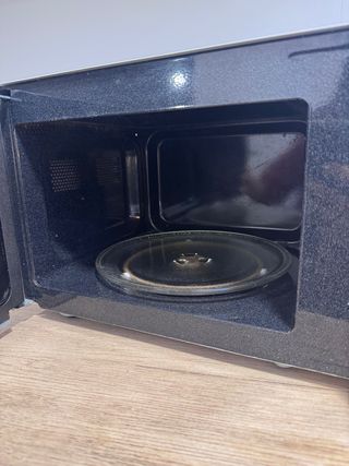 Microondas plateado con puerta de cristal