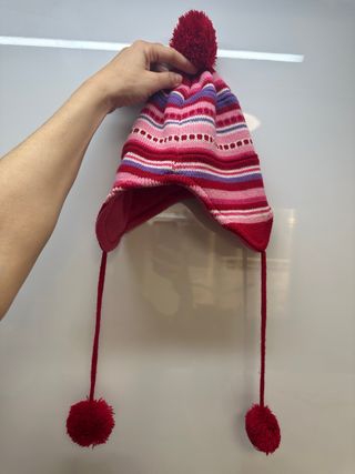 Gorro de punto con diseño a rayas y pompón.