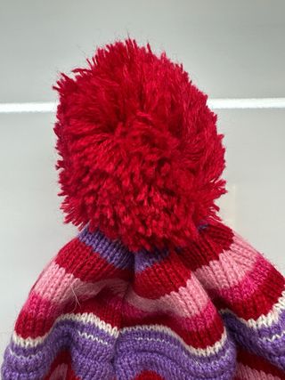 Gorro de punto con diseño a rayas y pompón.