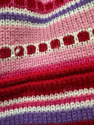 Gorro de punto con diseño a rayas y pompón.