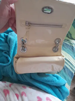 Bolso de mano beige con cadena plateada