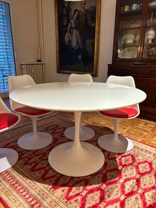 Mesa redonda blanca con 4 sillas blancas y rojas