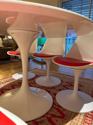 Mesa redonda blanca con 4 sillas blancas y rojas