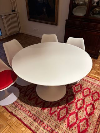 Mesa redonda blanca con 4 sillas blancas y rojas