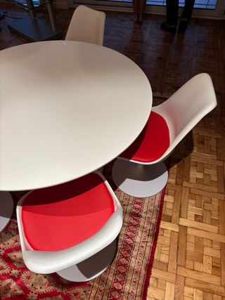 Mesa redonda blanca con 4 sillas blancas y rojas