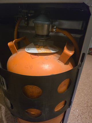 Estufa de gas Orbegozo con pantalla, ruedas, asas.