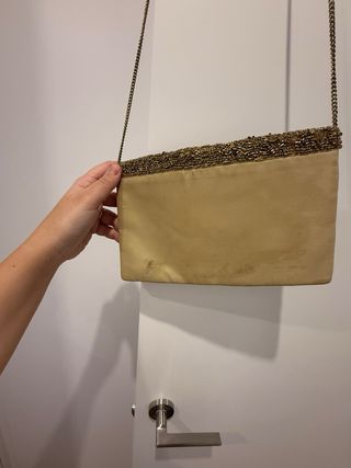 Bolso de mano dorado con cadena
