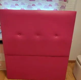 Cabecero tapizado rosa oscuro.