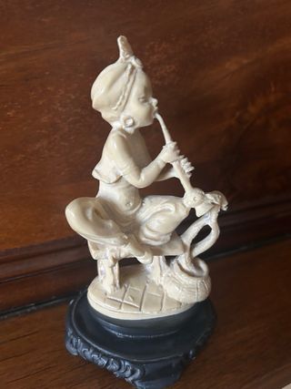 Figura marfilina músico con serpiente
