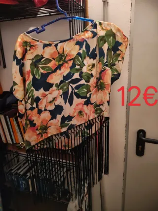 Top estampado floral con flecos largos en negro.