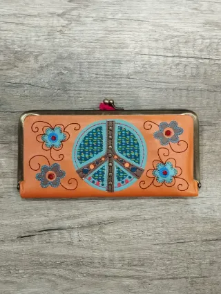 Monedero naranja con diseño de paz