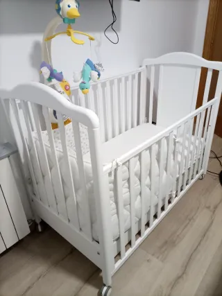 Cuna de bebé blanca con móvil