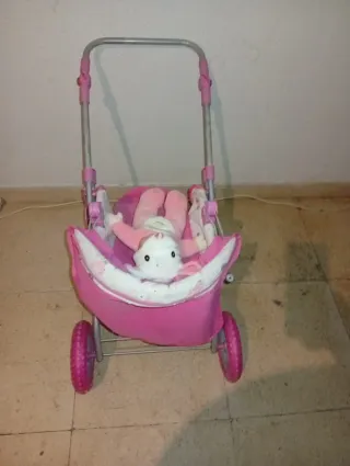 Carrito de muñecas rosa con muñeca