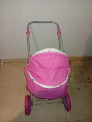 Carrito de muñecas rosa con muñeca